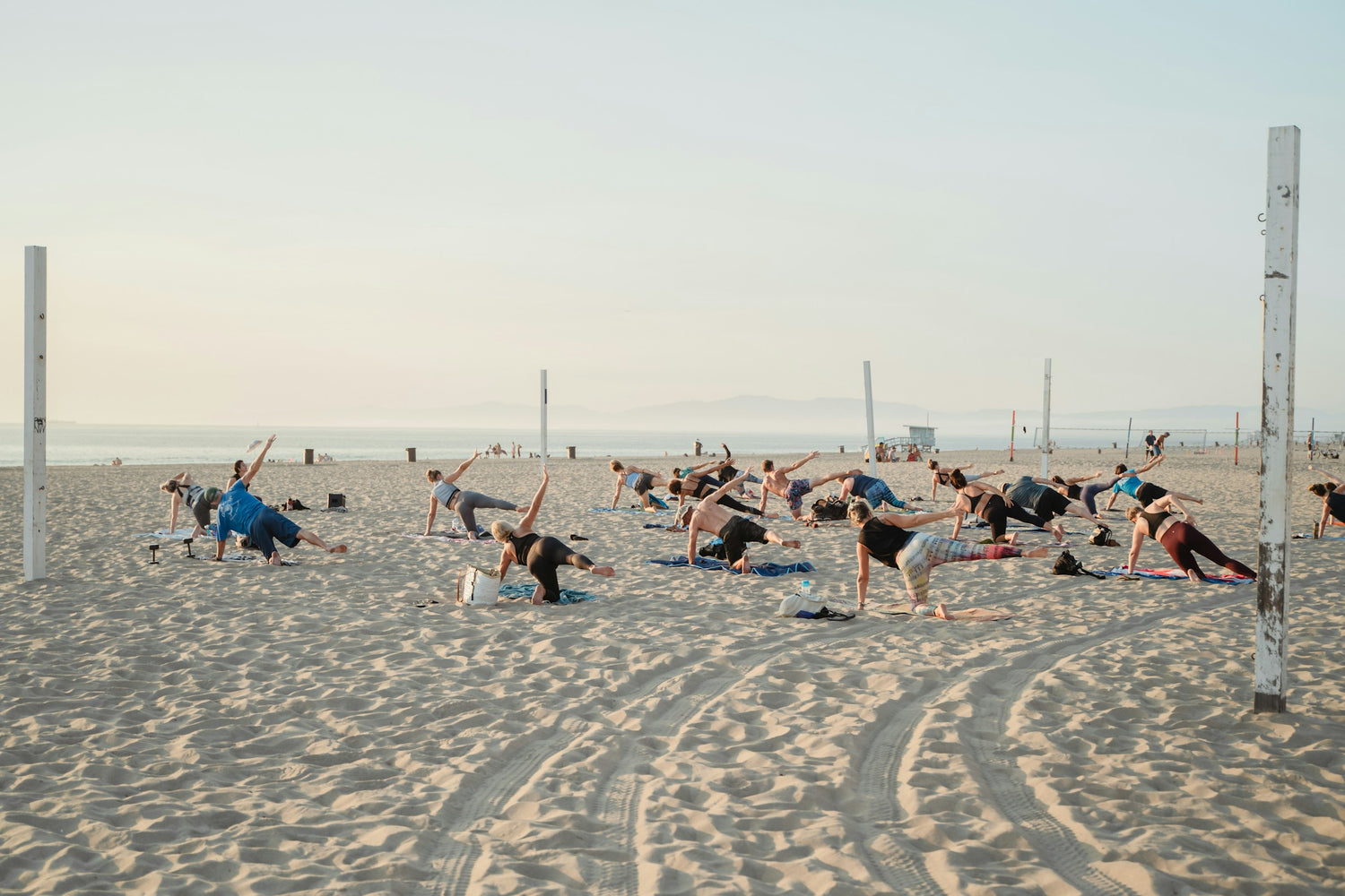 Group beach yoga at sunset