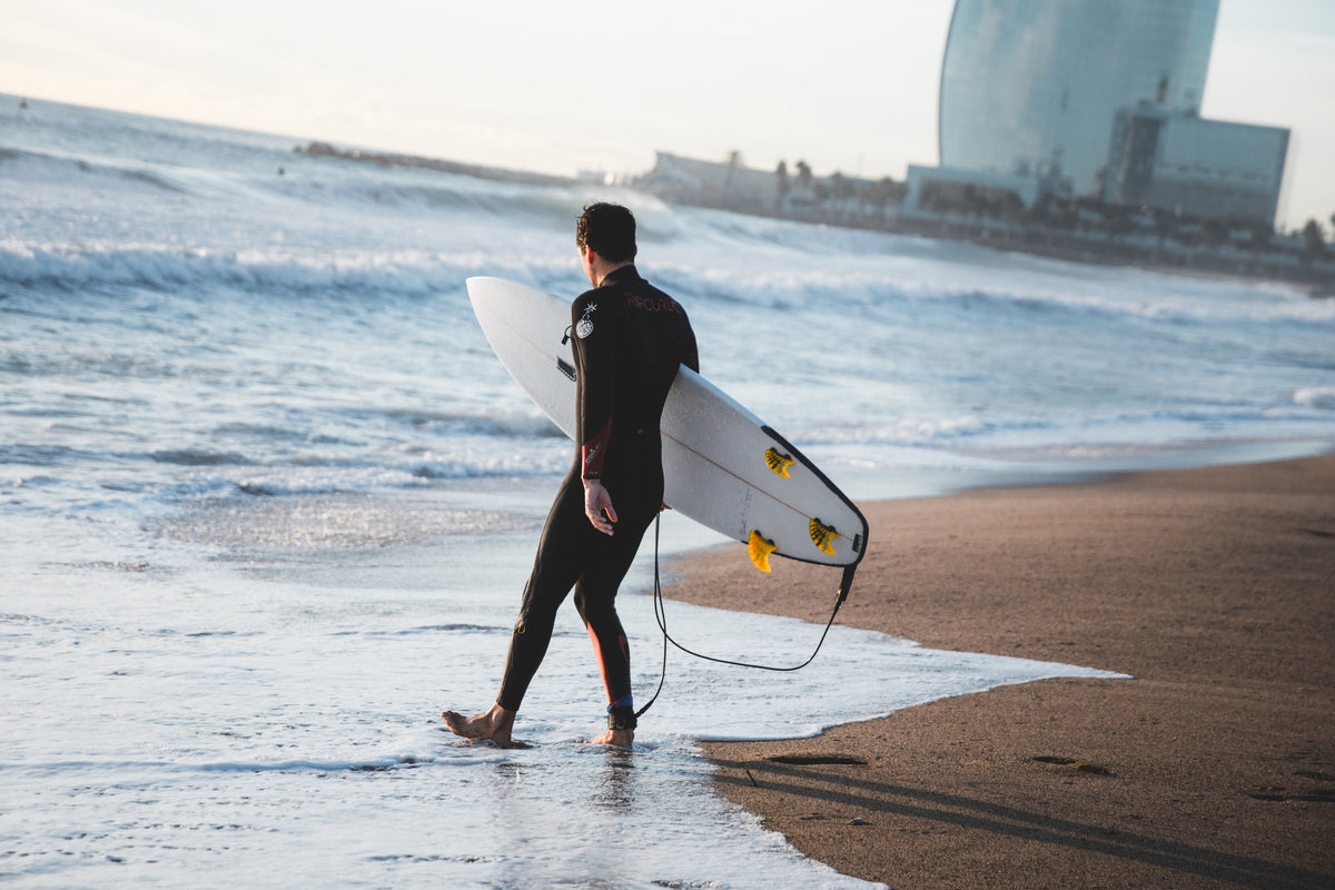Surfer carrying a board into the ocean